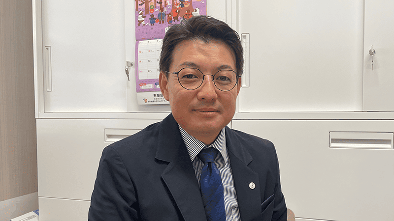 オフィスでスーツ姿の男性が座っている様子