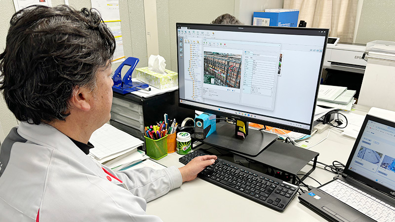 PRODOUGUをPCで操作している作業服の男性の写真
