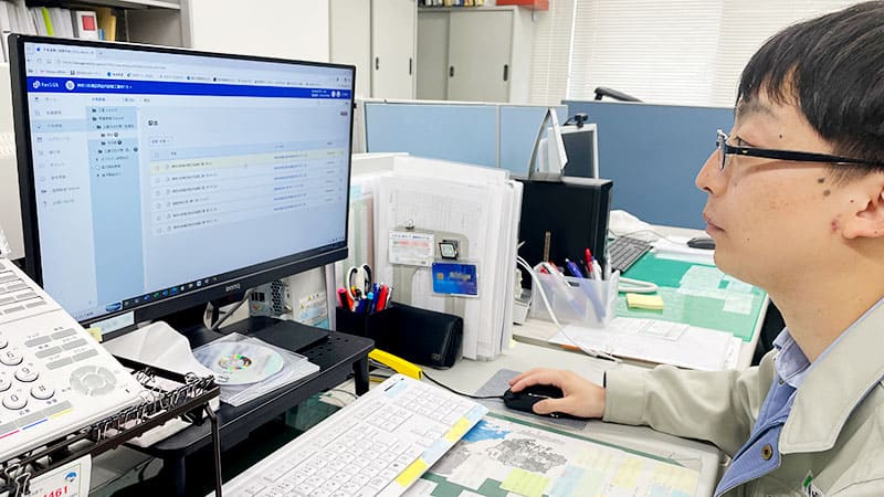 日成工事株式会社の営業部・不動産部 主任 三沢氏がPCを操作している様子