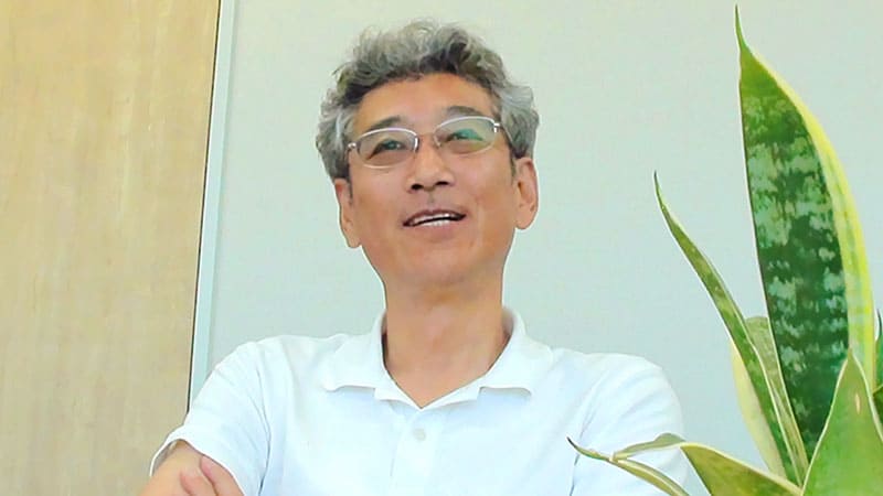眼鏡をかけた男性がインタビューを受けている様子