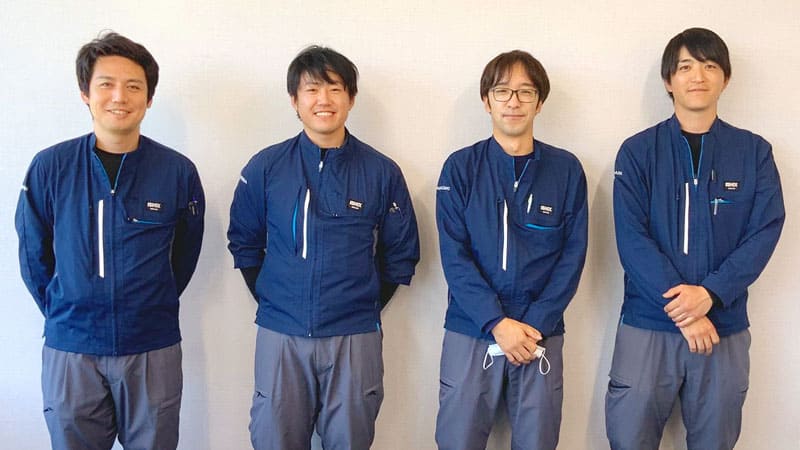 作業服を着た男性4人の集合写真