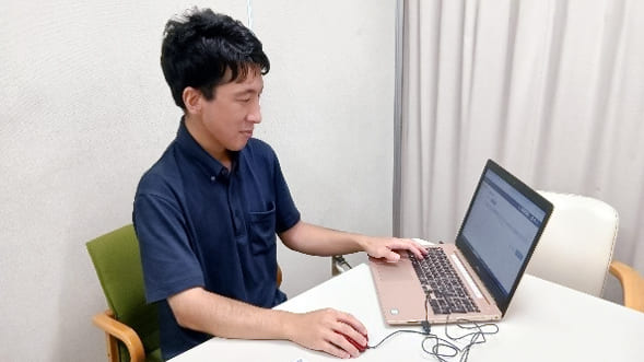 ノートパソコンを操作する男性の写真