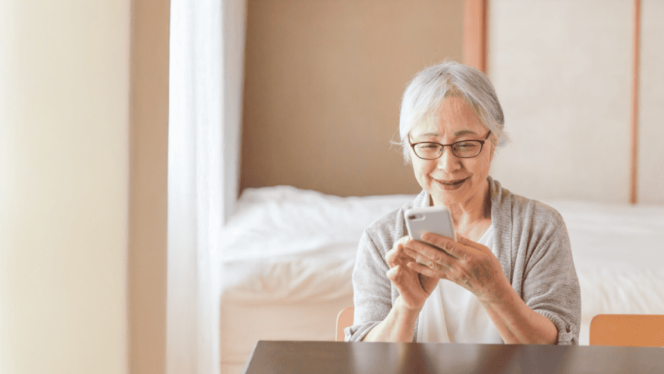 スマートフォンを使う高齢の女性の写真